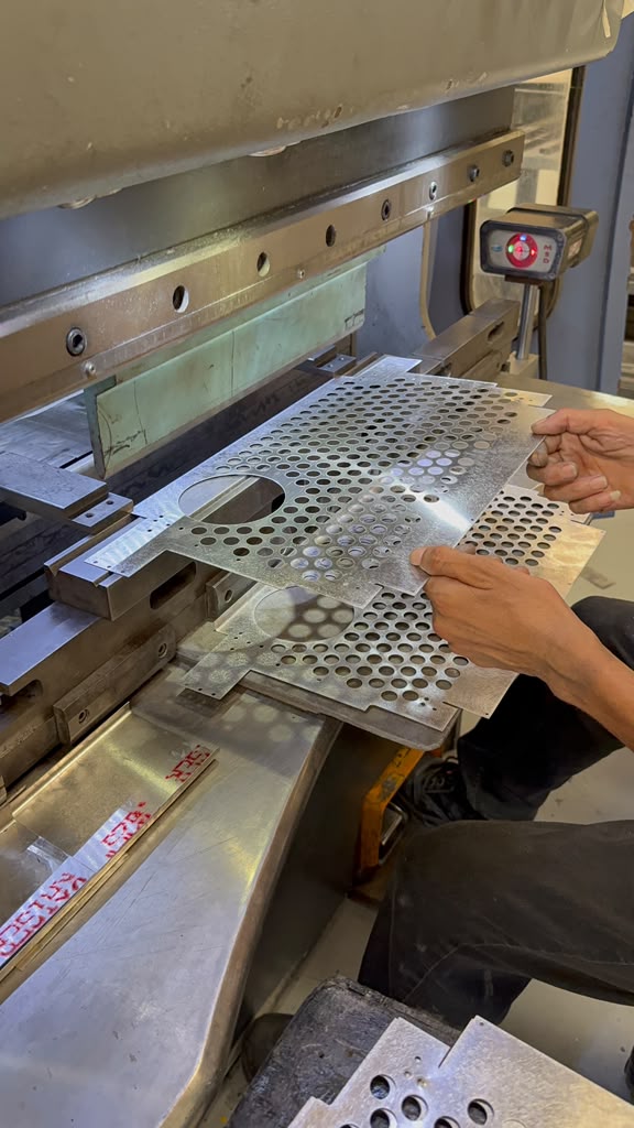 AMT operator forming a perforated sheet metal component on a press brake